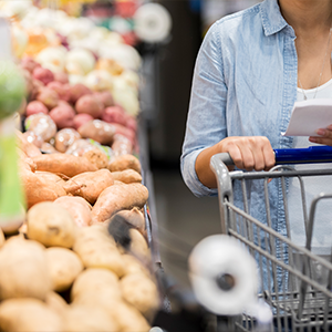 Women pushing cart through produce aisle 