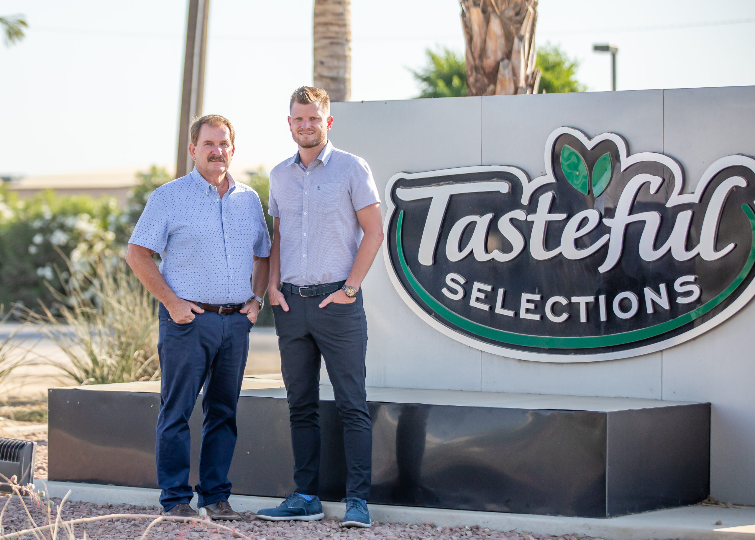 Bob and Nathan Bender in front of Tasteful Selections Sign