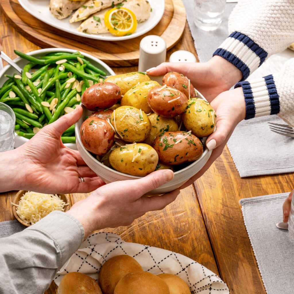 Passing Tasteful Selections potatoes across the table