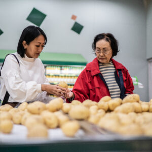 Mother and daughter choosing potatoes in a supermarket