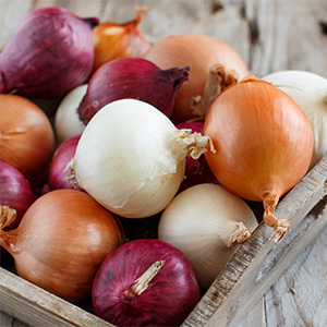 Yellow, white and red onions in a wooden box